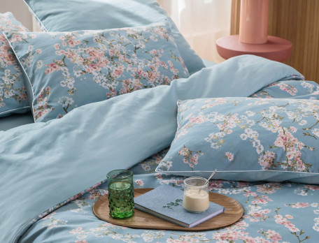 Linge de lit imprimé fleuri avec touches de blanc mat. Uni bleu ciel. Satin 100% coton, 118 fils/cm2. Florescence